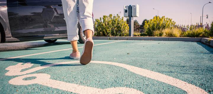 Vrouw stapt in haar elektrische auto na het opladen